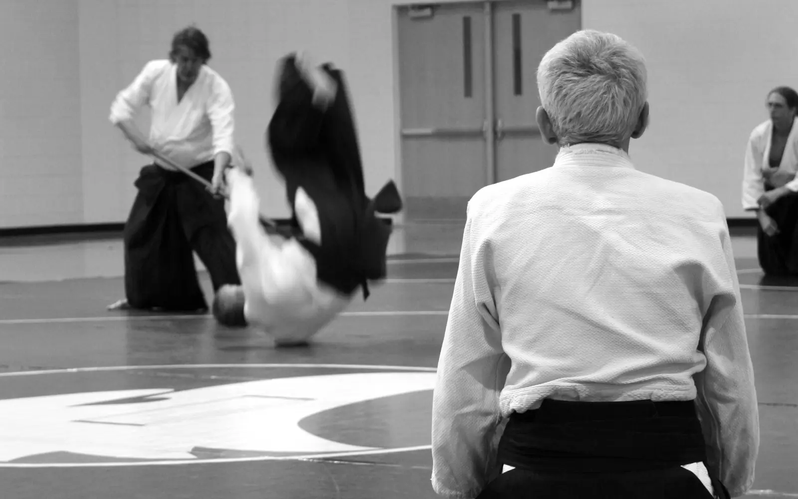 Cours d'aïkido : une projection sur le tapis, un pratiquant en seiza au premier plan. Photo de abelleee sur Pixabay