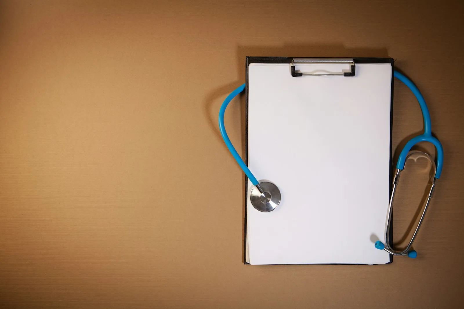 Stéthoscope posé sur un porte-document, illustrant le certificat médical demandé en club sportif