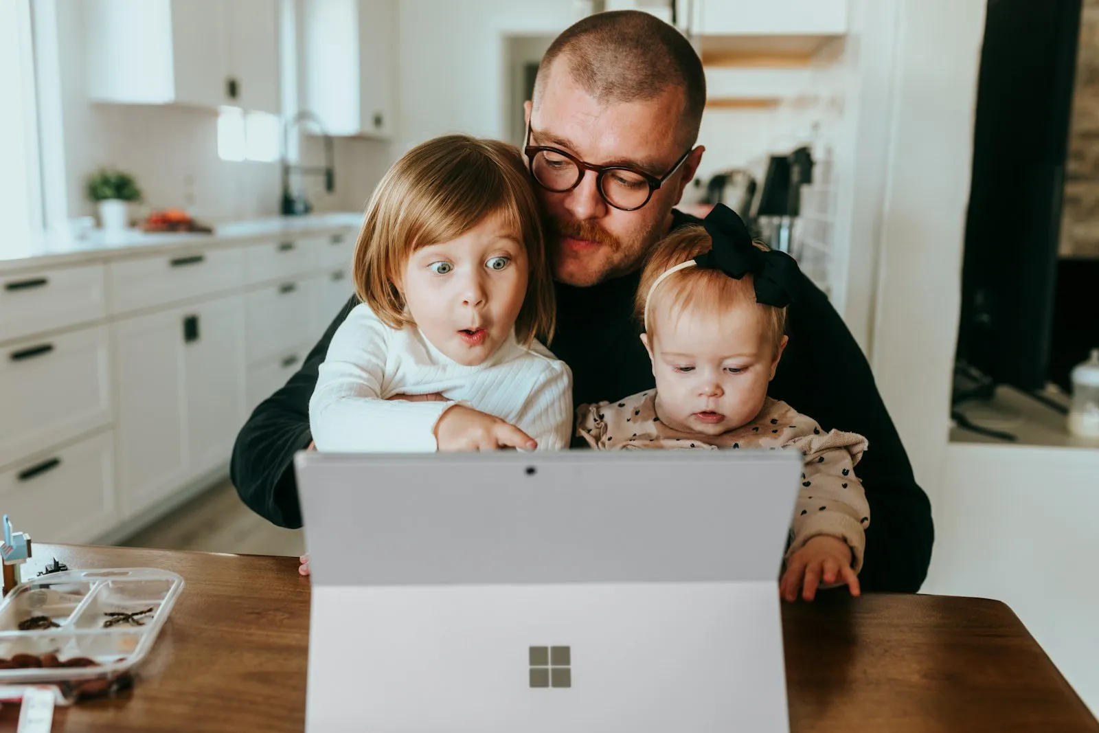 Parent inscrivant ses enfants en ligne depuis le canapé sur un ordinateur portable